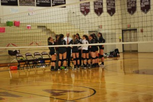 Varsity Volleyball Team in a Huddle Before the Game