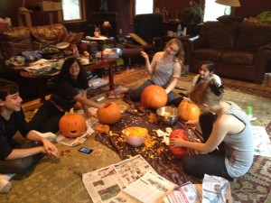 Ghostwriters Michael Tricca, Alisha Sabnis, and Ciara Barstow carving jack-o-lanterns with family