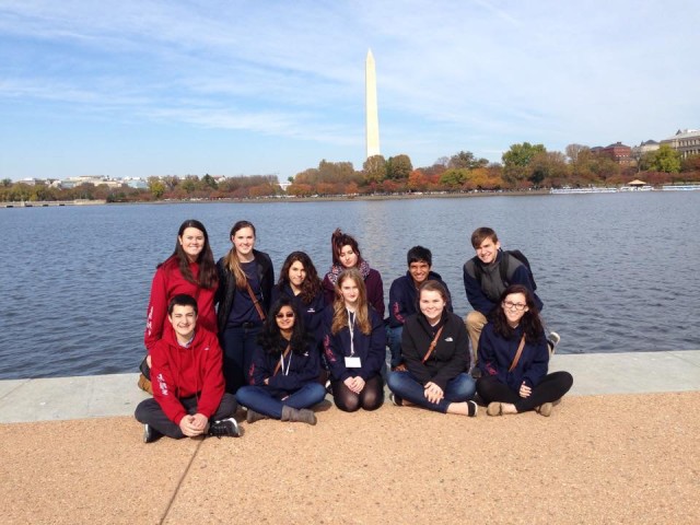 The staff poses in front of the Washington Monument.