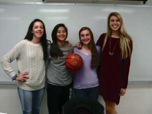 Captains and players pose with a basketball.